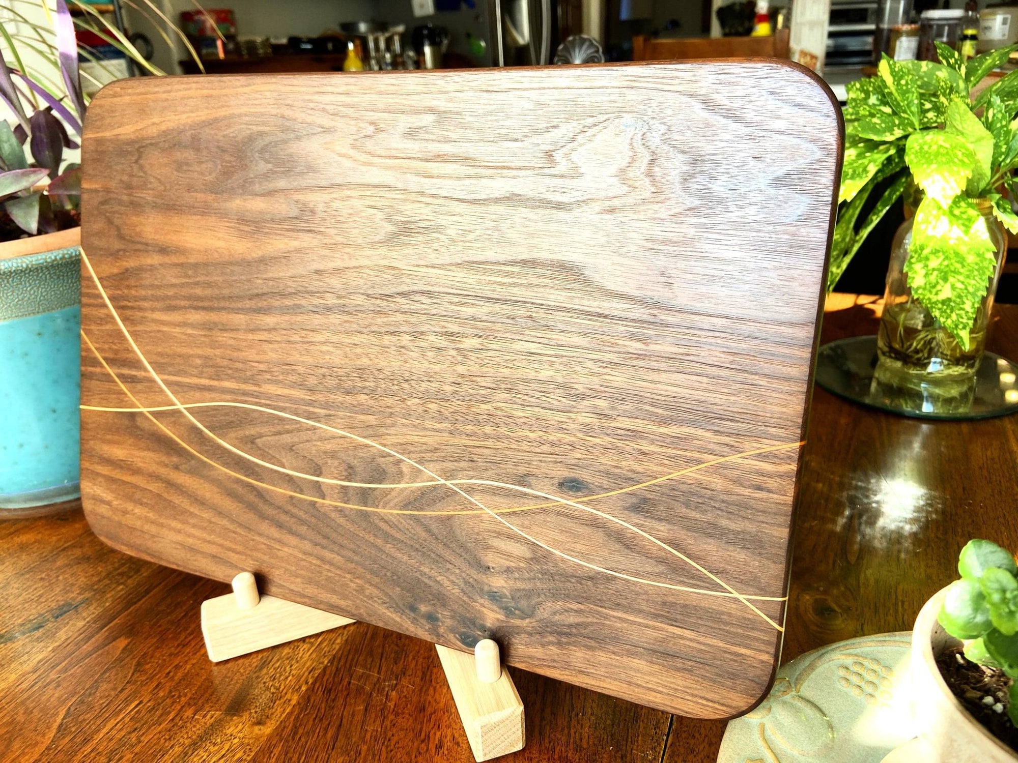 Peruvian Walnut charcuterie board with Maple and Cherry wood inlay on a table