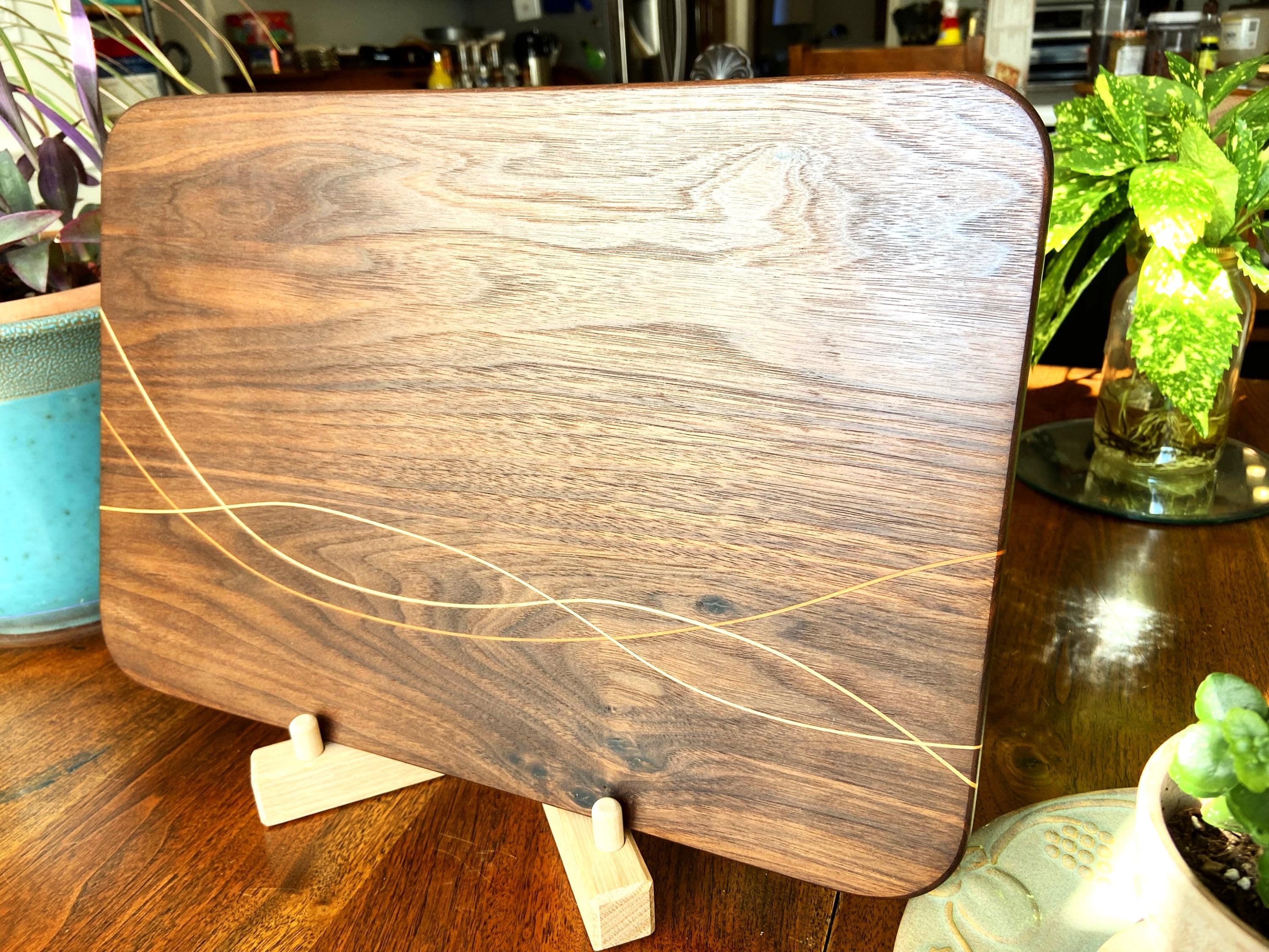 Peruvian Walnut charcuterie board with Maple and Cherry wood inlay on a table