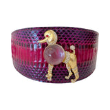 Wide collar with purple and pink textured reptile pattern featuring a gold-tone poodle brooch adorned with rhinestones and a large clear gem body