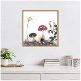 Square framed botanical print featuring two mushrooms—one with red cap and white spots, the other with a green cap—amid dried plants and moss on a white background.
