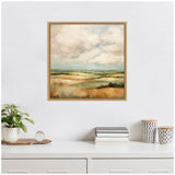 Square framed canvas depicting an abstract landscape of rolling hills under a cloudy sky, displayed above a white desk with minimalist decor.