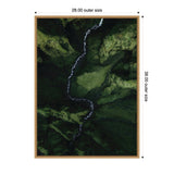 Framed aerial photograph of a winding white river flowing through a deep, mossy green valley with rugged terrain.