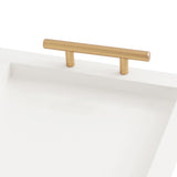 Close-up of a rectangular white decorative tray with a smooth surface and a cylindrical gold-toned handle centered on one edge.