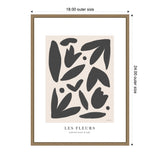Framed abstract wall art titled 'Les Fleurs' with black organic shapes on a pale beige background and minimal text below, in a light wood frame.