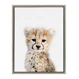 Framed canvas featuring a close-up portrait of a young cheetah with soft fur and distinct black tear markings on a white background.