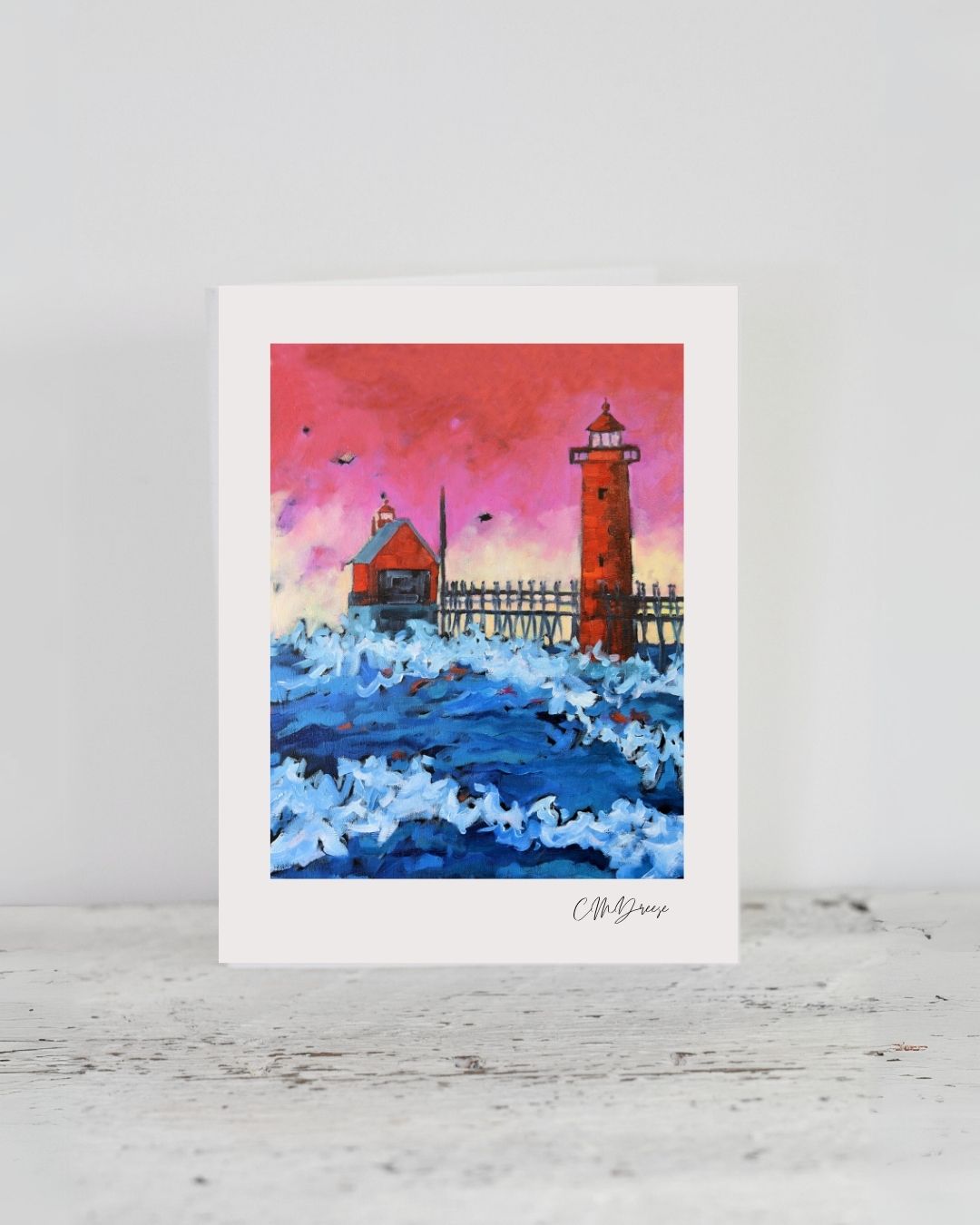 Notecard showing Grand Haven Lighthouse at dusk with pink sky reflecting over Lake Michigan