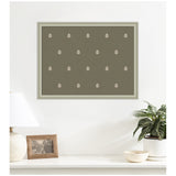 Green botanical block print featuring evenly spaced white leaf motifs in a grid pattern within a light gray frame, hanging above a white shelf with lamp, photo, and potted plant.