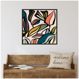 Abstract botanical artwork with large, overlapping leaves in muted tones of teal, coral, mustard, and black on a pale pink background in a black frame above a rustic wooden bench with a "welcome home" pillow.