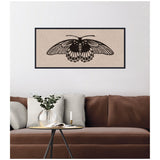 Framed canvas print of a black detailed butterfly illustration on a neutral linen textured background, hanging above a brown couch with gray cushions and a small round table.