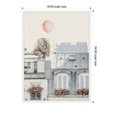 Small gray elephant clutching a pink balloon, sitting on the gray rooftop of a Parisian building with white windows and flower-adorned balconies below.