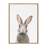 Portrait of a gray rabbit with upright ears and pink inner ear fur, centered against a plain white background in a simple light wood frame.