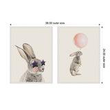 Two framed canvas arts side by side: left shows a gray bunny with purple star-shaped glasses and pink cheeks, right shows a gray bunny standing watching a large pink balloon above it.