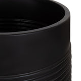 Close-up of a black matte cylindrical planter with horizontal ridges around its lower half on a white background.