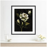 Framed floral artwork featuring a white peony with green leaves on a dark moody background, hanging above a light wooden shelf with glass candle and flower vase.