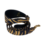 Black and gold zebra print leather dog collar with matching adjustable leash featuring gold hardware, shown coiled against a white background.