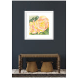 Framed watercolor painting of soft orange and pink begonia flowers with green leaves against a white background, hung on a dark wall above a wooden bench and woven baskets.