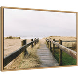 Framed canvas art depicting coastal beach boardwalk leading to ocean under cloudy sky
