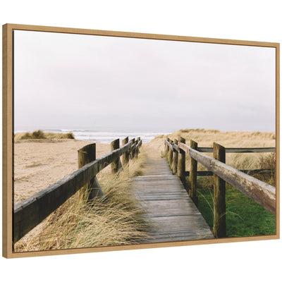 Framed canvas art depicting coastal beach boardwalk leading to ocean under cloudy sky