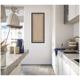 Minimalist kitchen with white cabinets, gray stone countertops, and a narrow beige wall hanging featuring a black scallop border in the center.