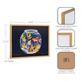 Framed art print showing a goldfish swimming in a glass bowl with pink and yellow foliage on a dark blue background, in a gold-finished oak wood frame.