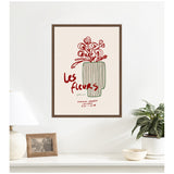 Minimalist wall art with red line-drawn flowers in a tall green striped vase, titled 'Les fleurs' in red cursive on a beige background framed in dark wood.
