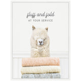 White alpaca with fluffy fur behind a stack of pastel pink, cream, and gray folded knit blankets, with text 'fluff and fold AT YOUR SERVICE' above