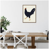 Minimalist framed canvas of a black rooster with red comb and yellow legs on a beige background, hanging above a wooden dining table with white chairs and cushions.