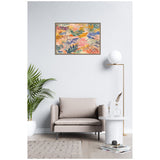 Abstract floral painting with pink, orange, green, and blue leaves and flowers in a thin wooden frame, hung on a white wall above a beige armchair in a minimalist living room.