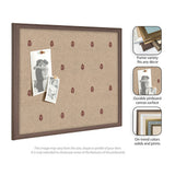 Rectangular pinboard with tan canvas featuring small red botanical prints, framed in dark wood, displaying two black-and-white photos pinned on the left side.