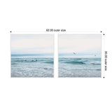 Two framed canvas prints side by side depicting a calm ocean scene with gentle waves, distant swimmers in one and birds flying over the water in the other.