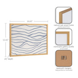 Minimalist coastal waves print with flowing gray lines on white, framed in natural oak wood with a gold finish and a slim gallery profile.