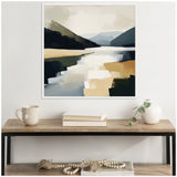 Abstract landscape canvas with muted blues, greens, and beige depicting mountains and a lake, hung above a wooden console table with books and a white vase