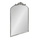 Arched rectangular mirror with a silver frame featuring intricate floral and scrollwork decoration at the top center.