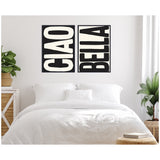 Two-piece black and white canvas wall art with bold vertical typography reading 'CIAO' and 'BELLA' displayed above a white bed with white bedding in a minimalistic bedroom accented by green plants.