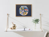 Wall-mounted white shelf with gold metal supports below a framed print of a goldfish swimming in a botanical-filled fishbowl against a dark background.