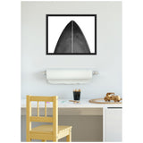 Minimalist black and white framed canvas of a black surfboard tip with a white dividing line, hanging above a desk with a paper roll, pencils, and a wooden toy truck.