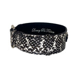 Black and white snake-patterned leather dog collar with silver buckle and stitching details, shown on a white background.