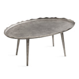 Oval coffee table with a textured dark metal top featuring wavy edges and supported by three slender cylindrical legs in matching finish.