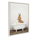 Framed canvas showing a baby donkey sitting in a white clawfoot bathtub filled with bubbles, with a small yellow rubber duck floating beside it.