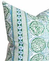 Close-up of a pillow cover with a Fair Isle pattern featuring repeating green circular leaf motifs and vertical blue and green geometric stripes on a white background.