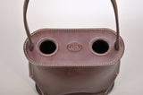Top view of a dark brown leather wine tote with two circular bottle openings and stitched edges, featuring an embossed oval logo in the center.