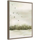 Framed canvas art depicting a winter landscape with evergreen trees and birds flying under a pale sky