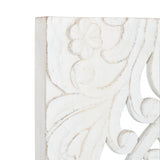 Close-up of white distressed carved wood panel featuring floral and scroll motifs with subtle beige highlights