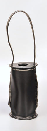 Black leather cylindrical wine tote with white stitching and a single tall, curved handle extending from the top, shown on a plain white background.