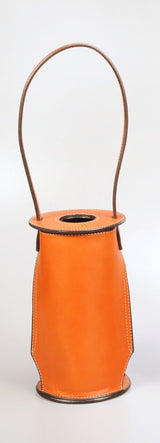 Tall, cylindrical orange leather wine tote with black stitching and a narrow handle arching over a circular top opening.