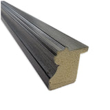 Close-up of a black wood-textured frame molding with a grooved profile and a beige compressed wood core, shown at an angle against a white background.