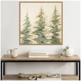 Abstract painting of three green evergreen trees with loose brushstrokes on a cream background, framed in light wood, hanging above a wood and black metal console table.