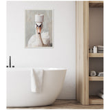Framed canvas of a white swan with an orange-beaked head balancing a toilet paper roll on top, hanging above a white bathtub in a minimalist bathroom.