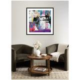 Abstract wall art with black brushstrokes, pink and purple accents, and layered blue and beige tones, framed in black and displayed above two gray armchairs.