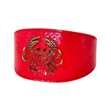Wide red collar with a glossy snake texture featuring a gold-tone rhinestone crab shaped accessory in the center front.